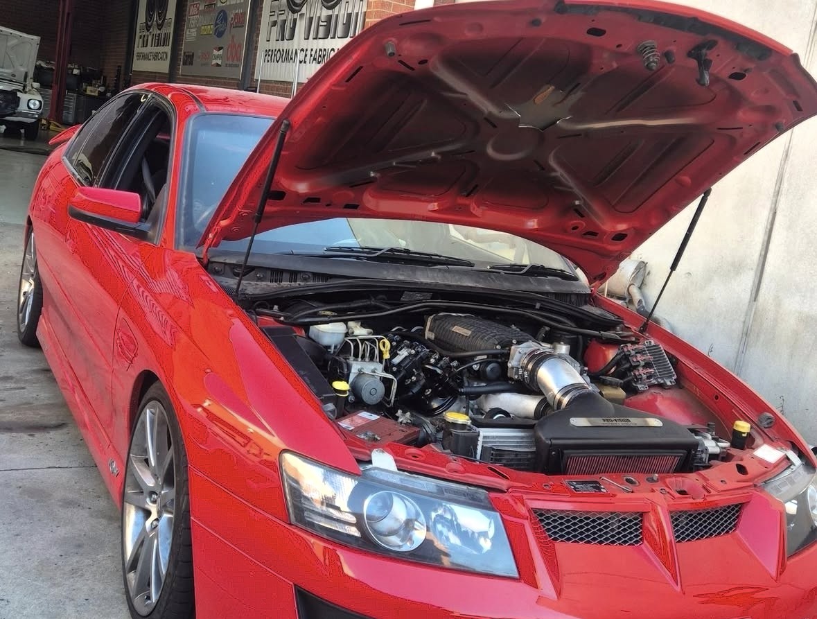 Red Holden receiving under-bonnet mechanical work