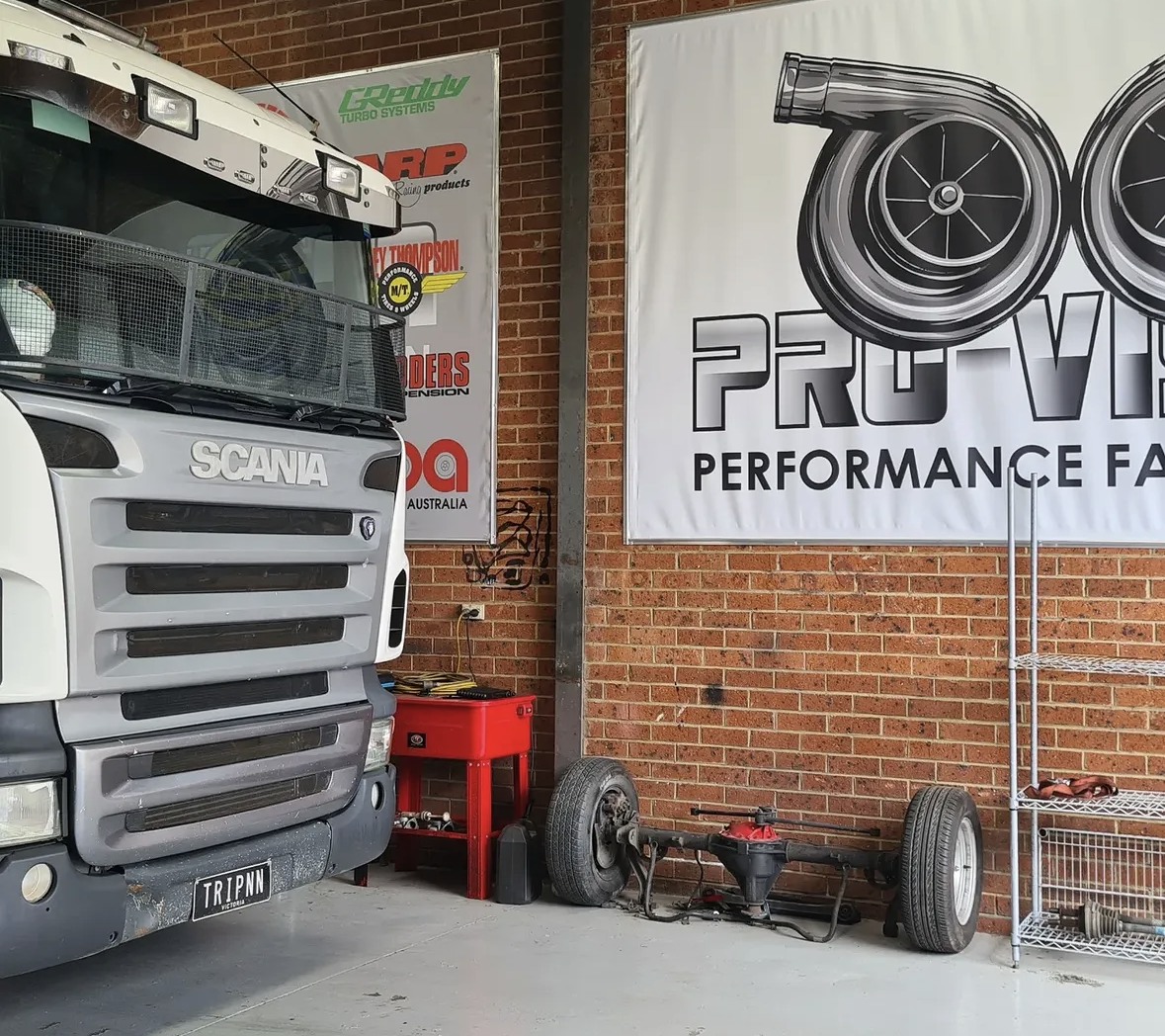 Scania truck beside a Pro-Vision workshop sign
